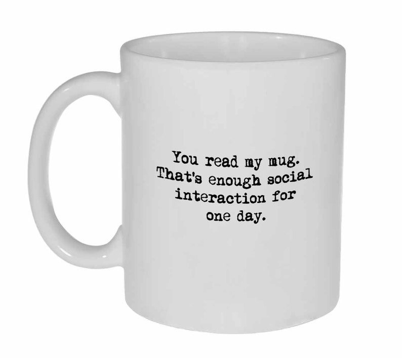 Op de afbeelding: Een witte keramische mok met zwarte tekst die "You read my mug. That's enough social interaction for one day." zegt.