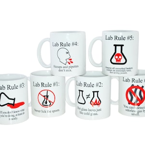 May include: Six white ceramic mugs with black text and red illustrations. Each mug has a different lab rule written on it, such as "Never lick the spoon" and "Hiccups and pipettes don't mix".