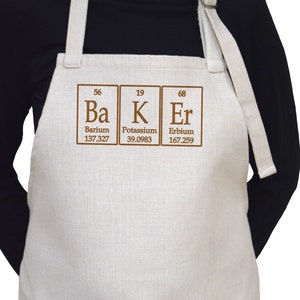 May include: A white linen apron with brown text that reads "Ba K Er" with the atomic numbers and weights for Barium, Potassium, and Erbium.