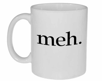 May include: White ceramic coffee mug with black text that reads "meh."
