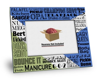 May include: A green, white, and blue picture frame with a variety of words printed on the frame. The frame has a brown cardboard box with a red brain inside. The text on the box reads "Neurons Not Included".