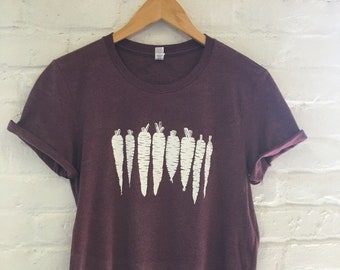May include: A maroon t-shirt with a white graphic of a row of carrots.