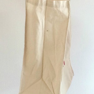 May include: A plain white canvas tote bag with a red logo on the side.