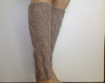 May include: A pair of beige knitted leg warmers with a delicate leaf pattern.