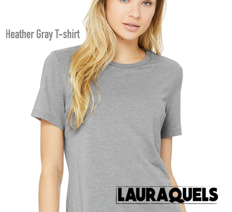 Puede incluir: Una camiseta gris jaspeado con mangas cortas y cuello redondo. La camiseta est&aacute; hecha de un material suave y c&oacute;modo. El texto "Heather Gray T-shirt" se muestra en la parte superior izquierda de la imagen. El nombre de la marca "LAURAQUELS" se muestra en la parte inferior derecha.