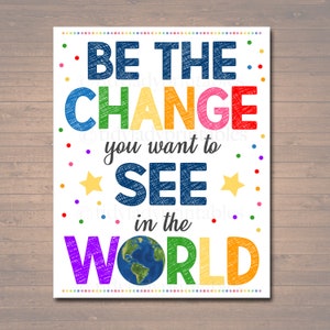 May include: A colorful poster with the text "Be the change you want to see in the world". The text is written in a rainbow of colors and has a scribbled, hand-drawn look. A small image of the Earth is in the center of the poster.