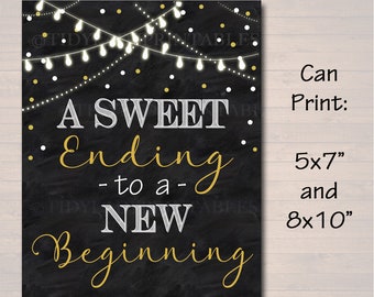 Puede incluir: Impresión en estilo pizarra negra con el texto "A Sweet Ending - to a - New Beginning" en letras blancas y doradas. El diseño incluye luces de cadena y está disponible en tamaños de 12,7 x 17,8 cm y 20,3 x 25,4 cm.