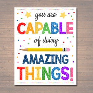 May include: A white printable poster with the text "You are capable of doing amazing things!" in rainbow colors with a yellow pencil drawn on top of the text. The poster is decorated with yellow stars and colorful dots.