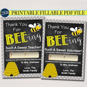Può includere: Carta di ringraziamento stampabile con un design di ape e favo. La carta dice "Grazie per BEE-ing Such A Sweet Teacher!" e "Grazie per BEE-ing Such A Sweet Volunteer!" con spazio per inserire il nome e un messaggio.