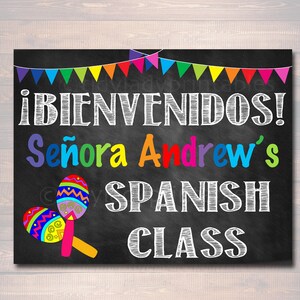 May include: A black chalkboard sign with colorful pennant flags at the top. The sign says "&iexcl;BIENVENIDOS! Se&ntilde;ora Andrew's SPANISH CLASS" in white chalk. There are two colorful maracas on the left side of the sign.