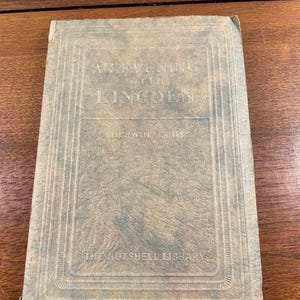 May include: A rectangular hardcover book with a weathered, mottled tan and grey cover. The front features the embossed text AN EVENING WITH LINCOLN, the author name SHERWIN CODY, and the series title THE NUTSHELL LIBRARY, all framed by borders.
