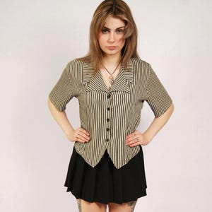 May include: A set of three ceramic nesting bowls in graduating sizes. The bowls feature a speckled, cream-colored exterior and a contrasting dark brown interior. The largest bowl measures approximately 8 inches in diameter.