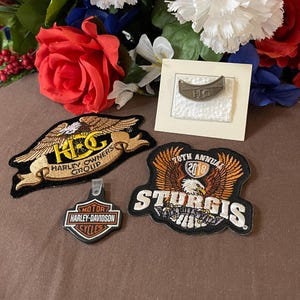 May include: Four embroidered patches with an eagle design. The patches are black, brown, and white with yellow and orange accents. The patches feature the text "H.O.G. Harley Owners Group", "78th Annual 2018 Sturgis", and "Motor Harley-Davidson Cycles".