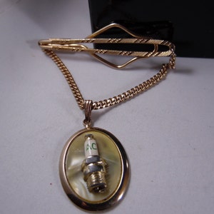 Gold Tone Tie Clip Bar With Chain And  A C Spark Plug with Mother of Pearl Back Ground Gold Tone