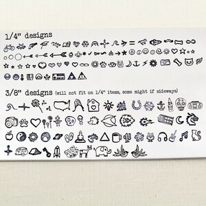 May include: A sheet of metal with a variety of small, black, stamped designs. The designs are organised into two sections, labelled "1/4" designs" and "3/8" designs". The designs include symbols, animals, and objects.