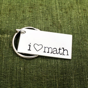 May include: Silver keychain with a rectangular tag that says "i ♥ math".