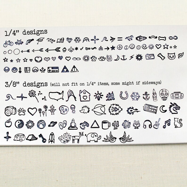 May include: A sheet of metal with a variety of small, black, stamped designs. The designs are organised into two sections, labelled "1/4" designs" and "3/8" designs". The designs include symbols, animals, and objects.