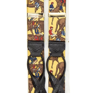 May include: Yellow suspenders with a repeating pattern of jockeys on horseback. The suspenders have black leather ends and metal clasps. The design features brown horses and riders in various colored silks.