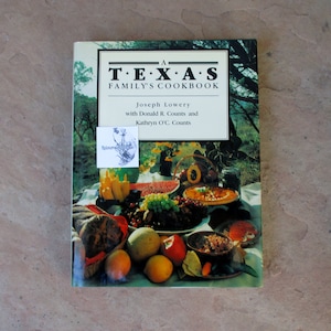 May include: A Texas Family's Cookbook by Joseph Lowery, with a colorful image of a table laden with food. The cover features the title in a bold font, with a sticker in the upper left corner.