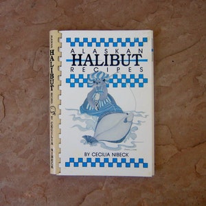 May include: A vintage cookbook titled "Alaskan Halibut Recipes" by Cecilia Nibeck. The cover features a blue and white checkered border and an illustration of a bear fishing for a halibut. The book is open, showing the spiral binding.