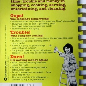 May include: A vintage cookbook cover with a bright yellow background and white spiral binding. The cover features text about saving time and money in the kitchen, along with humorous cooking mishaps and a cartoon illustration of a person on a step stool.