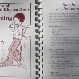May include: An open book with a spiral binding, featuring a cartoon illustration of a boy and a dog. The text reads "The Best of Helpful Kitchen Hints for Cleaning" and cleaning tips.