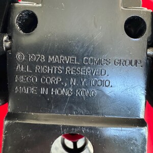 Pu&ograve; includere: Macchina giocattolo in plastica nera con carrozzeria rossa e ruote nere. La parte inferiore dell'auto ha il testo "1978 MARVEL COMICS GROUP. ALL RIGHTS RESERVED. MEGO CORP., N. Y. 10010. MADE IN HONG KONG".