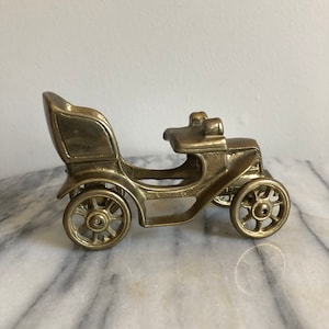 vintage brass car with wheels that roll