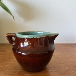 La brocca per crema di coccio vintage in gres sembra un&#39;acqua marrone ala rossa