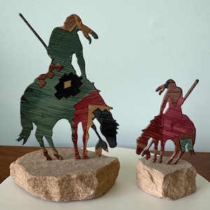 pair of metal and stone end of trail sculpture