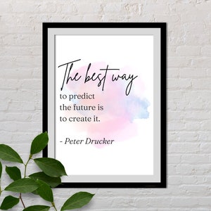 May include: A framed print with a watercolor background in shades of pink and blue. The print features a quote by Peter Drucker: "The best way to predict the future is to create it."