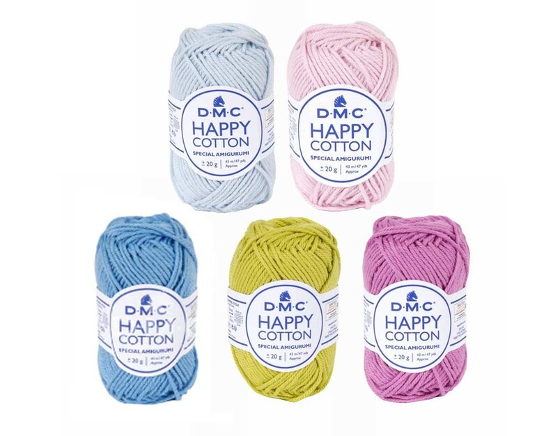 May include: Five balls of DMC Happy Cotton yarn in different colors: light blue, blue, green, pink, and light pink. Each ball has a label that says "D-M-C Happy Cotton Special Amigurumi 20g".