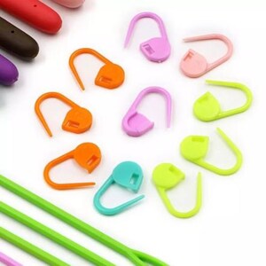 Pu&ograve; includere: Assortimento di marcatori di punti in plastica colorati in varie forme, tra cui cerchi, ovali e forme a goccia. I marcatori vengono utilizzati per marcare l'inizio o la fine di una riga di punti a maglia o all'uncinetto.