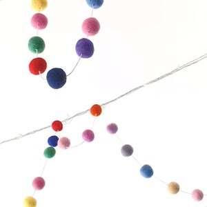 Puede incluir: Una cadena de luces de bolas de fieltro de colores, perfecta para a&ntilde;adir un toque de fantas&iacute;a a cualquier habitaci&oacute;n. Las luces est&aacute;n enhebradas en un cable transparente y presentan una variedad de colores, incluyendo rojo, naranja, amarillo, verde, azul, morado y rosa.