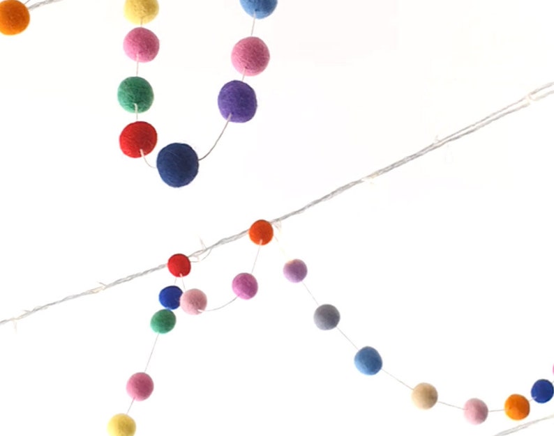 Puede incluir: Una cadena de luces de bolas de fieltro de colores, perfecta para a&ntilde;adir un toque de fantas&iacute;a a cualquier habitaci&oacute;n. Las luces est&aacute;n enhebradas en un cable transparente y presentan una variedad de colores, incluyendo rojo, naranja, amarillo, verde, azul, morado y rosa.