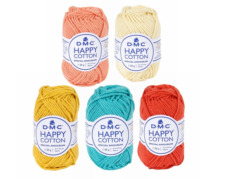 Pu&ograve; includere: Cinque gomitoli di filato DMC Happy Cotton in vari colori: corallo, giallo, turchese, rosso e crema. Ogni gomitolo &egrave; etichettato con il logo DMC e il testo "Happy Cotton" e "Special Amigurumi".