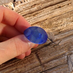 May include: A blue faceted glass bead with a smooth, polished surface.