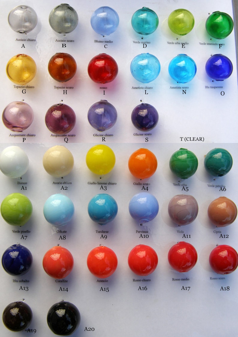 May include: A chart with 20 glass beads in different colors and shades. The beads are labeled with Italian names for the colors, such as "rosso" for red, "bluino" for blue, and "verde" for green. The beads are arranged in rows and columns, and each bead is labeled with a letter and number.