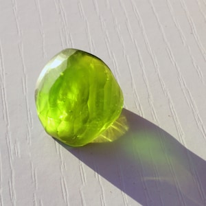 May include: A bright green, faceted glass sphere with a smooth, shiny surface.