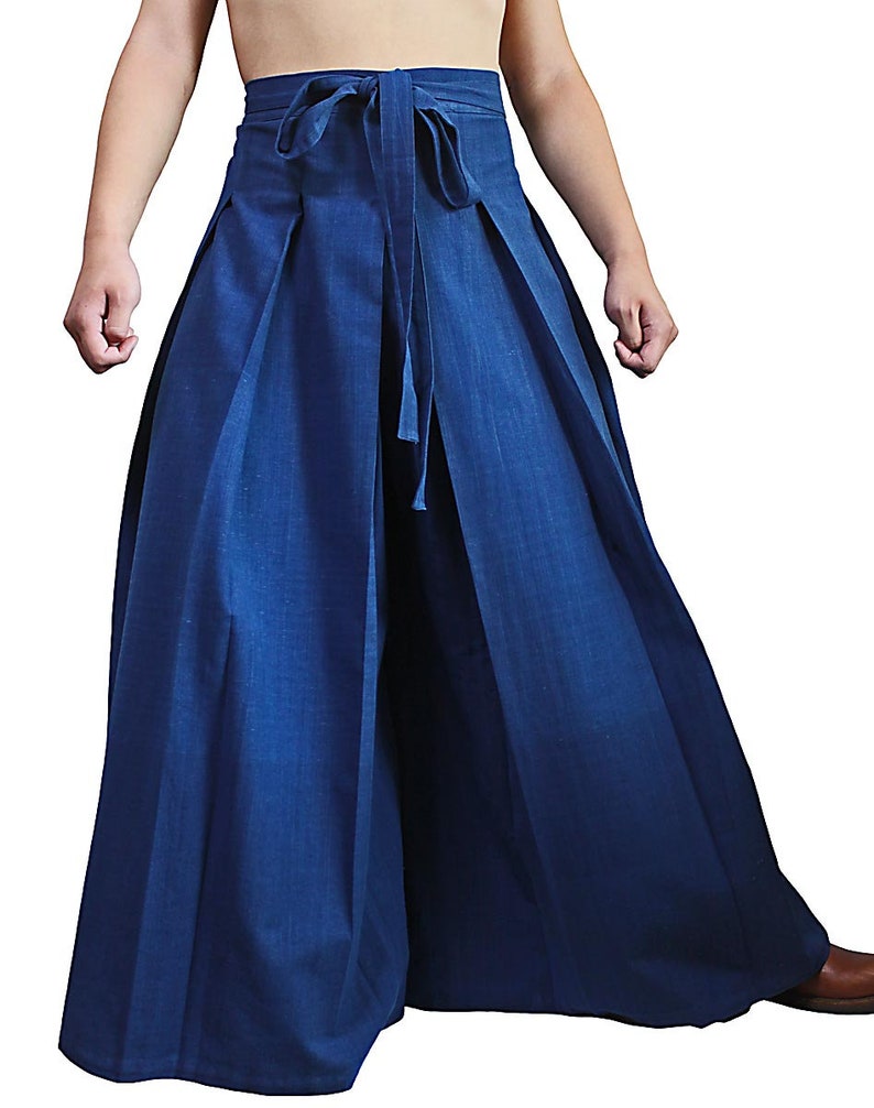 May include: A pair of wide-legged pants with a tie at the waist. The pants are a dark blue color and have pleats down the front.