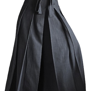 May include: A black pleated skirt with a wide waistband and a tie at the waist.