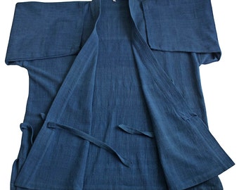 May include: A blue kimono-style robe made of a lightweight fabric. The robe has wide sleeves and a wrap-around design with a tie closure. The garment is laid flat, showcasing its open front and the texture of the material.