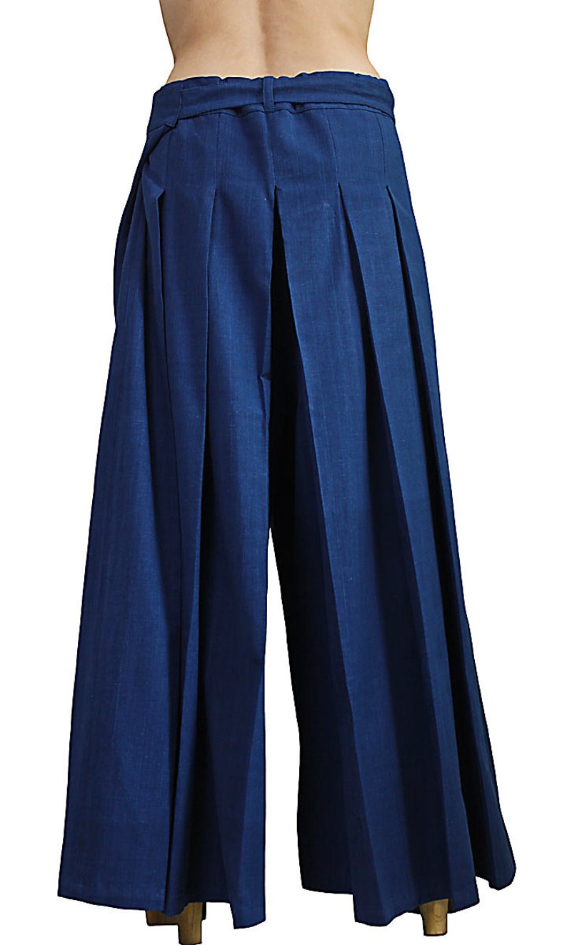 May include: Dark blue wide-leg pants with pleats and a waistband with a tie.