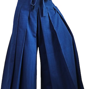 May include: Wide-leg, pleated pants with a tie waist. The pants are a deep blue color and made of a lightweight fabric.