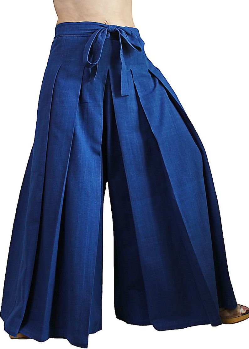 May include: Wide-leg, pleated pants with a tie waist. The pants are a deep blue color and made of a lightweight fabric.