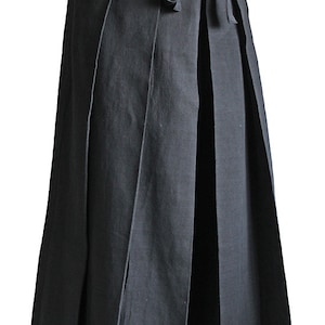 May include: A black wrap skirt with pleats and a tie belt. The skirt is made of a soft, comfortable fabric and is long enough to reach the ankles.