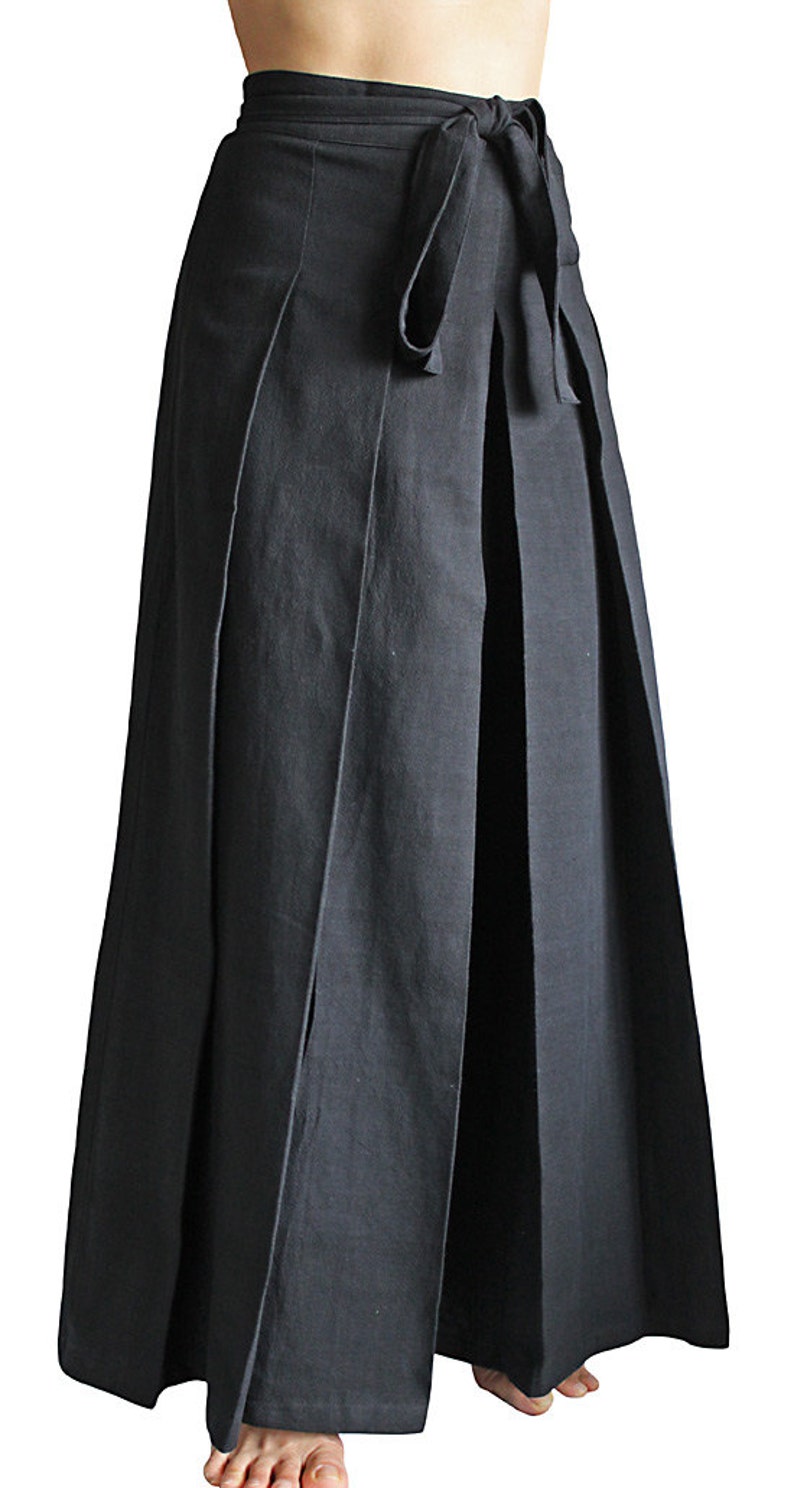 May include: A black wrap skirt with pleats and a tie belt. The skirt is made of a soft, comfortable fabric and is long enough to reach the ankles.