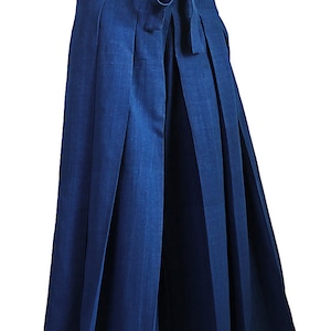 May include: A pair of wide-leg, pleated pants in a deep blue color. The pants have a tie at the waist and are made of a lightweight fabric.