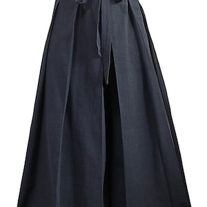 May include: Black wide-leg pants with a pleated front and a tie at the waist.