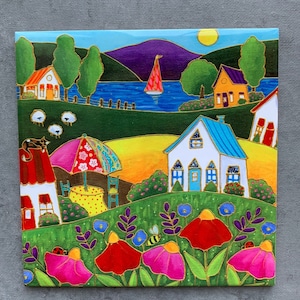 May include: A vibrant painting depicting a sunny landscape with houses, flowers, and a sailboat on a lake. The artwork features a bright colour palette with gold accents, including red, pink, blue, and yellow. A bee and ladybug are also visible.